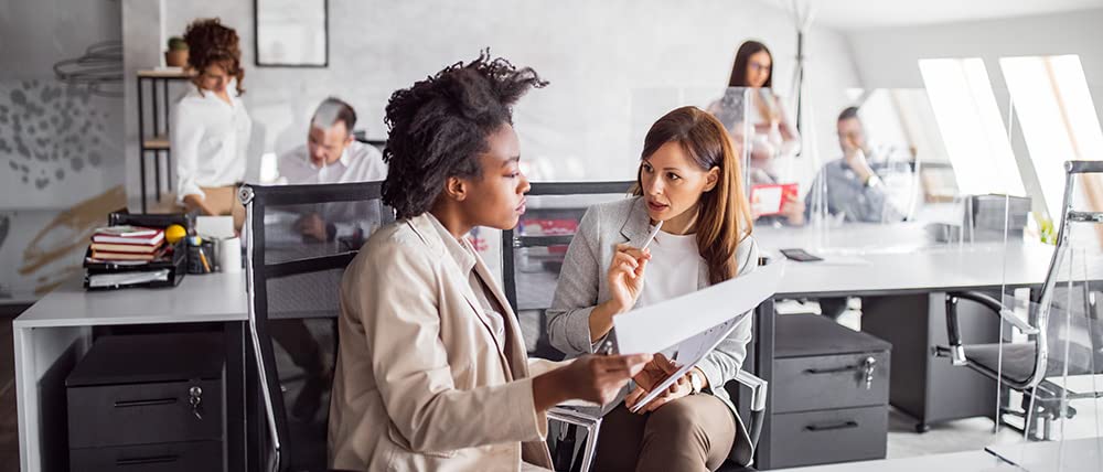 Dos mujeres analizan estrategias de marketing de comercio electrónico