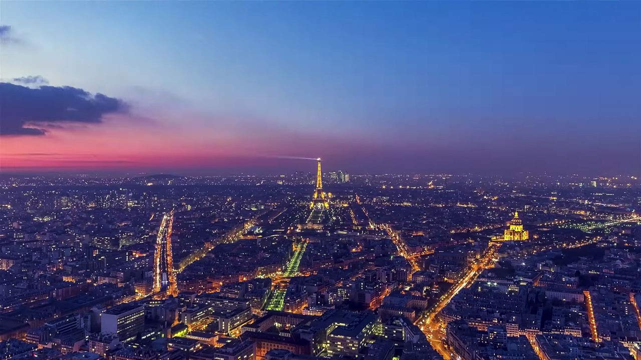 miniatura de video que muestra un paisaje de la ciudad al anochecer, las luces iluminan las carreteras