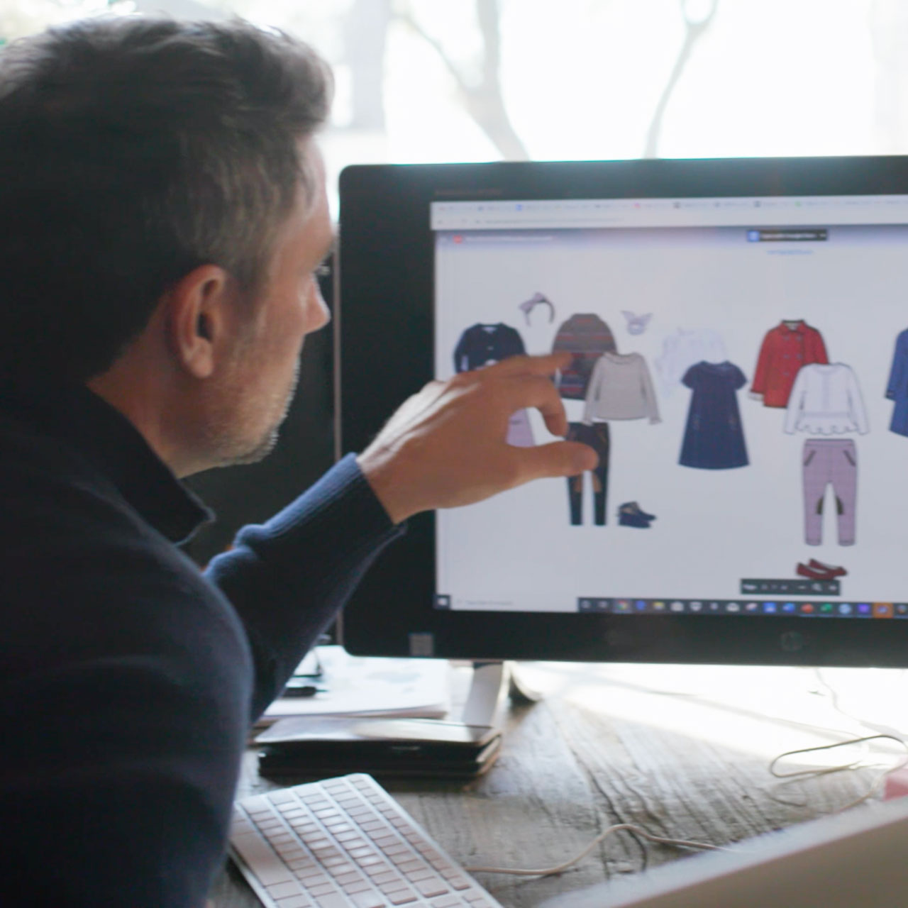 man pointing at a computer screen with children's clothes from Amazon seller Hope and Henry